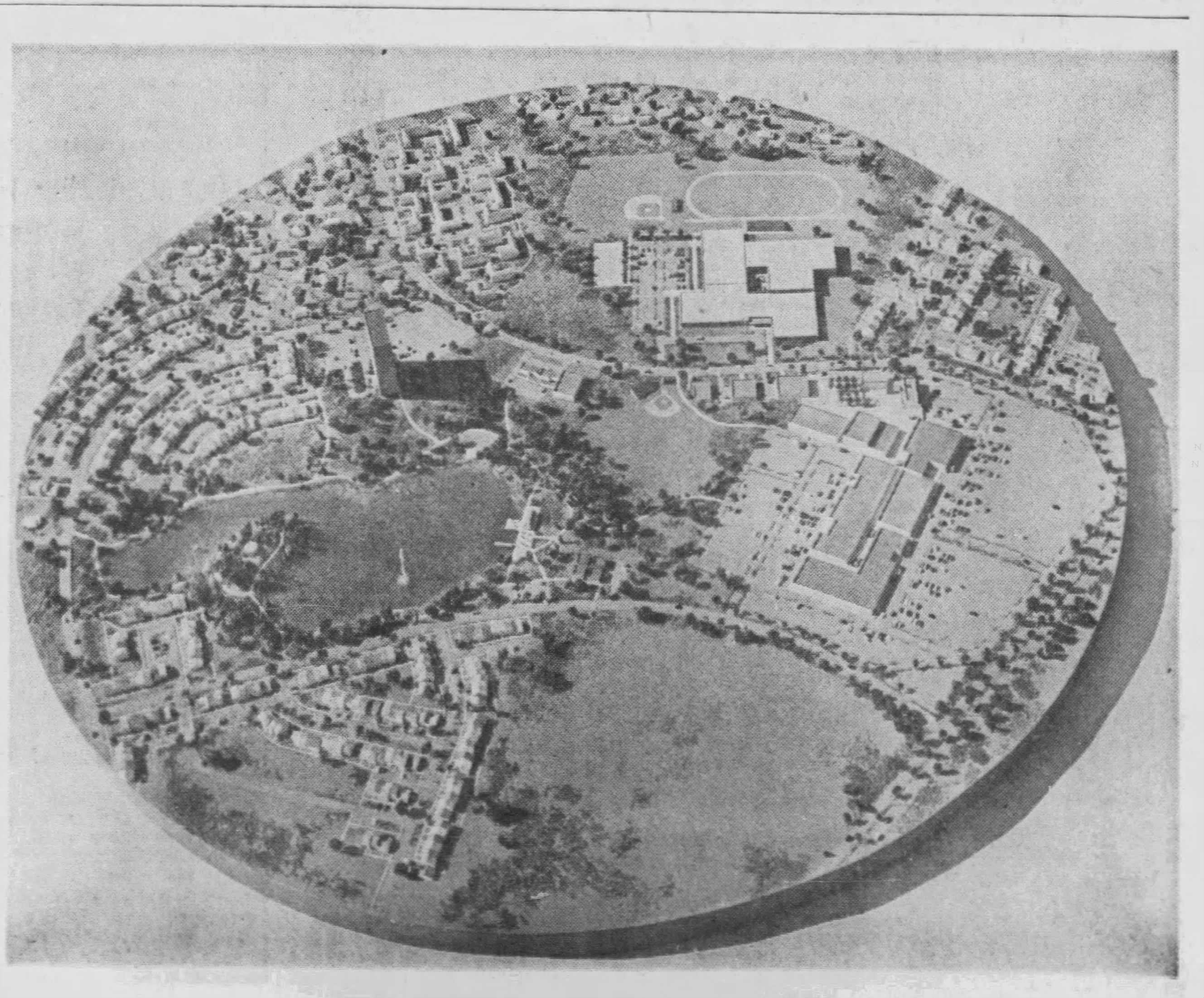 Aerial photograph of Levitt and Sons scale model of the Belair Village planned community, published in The Record (Hackensack, NJ), March 15, 1968. The oval-shaped model shows the town center, school campus with stadium, residential clusters, and Allen Pond with its wooded island.
